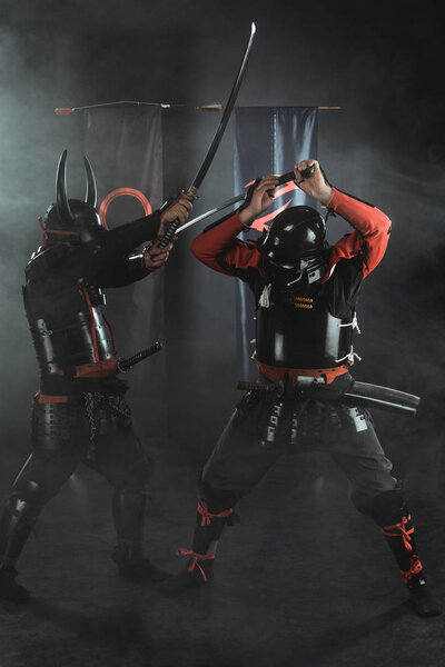 traditional armored samurai fighting with swords on black