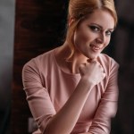 Close-up portrait of beautiful young woman in pink dress looking at camera