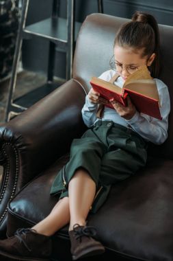 sevimli küçük çocuk okuma kitabı evde kanepede yüksek açılı görünüş