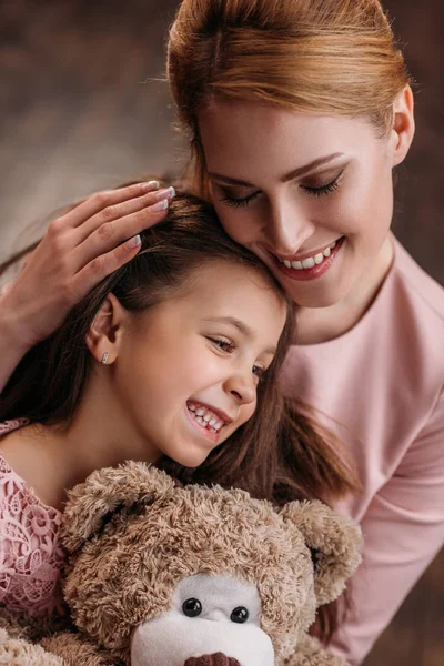 Primer Plano Madre Abrazando Hija Mientras Ella Sostiene Oso Peluche —  Fotos de Stock