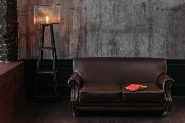 interior of stylish room in loft design with book lying on couch