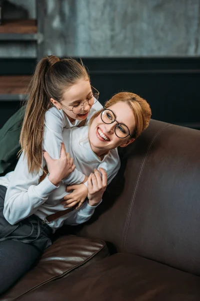 Feliz Adorável Filha Abraçando Sua Mãe Por Trás Sofá Casa — Fotografia de Stock