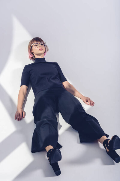 стильная девушка, лежащая с закрытыми глазами на белом
