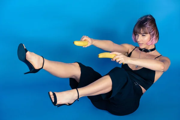 Stylish Girl Sitting Holding Bananas Hands Front Her Isolated Blue — Stock Photo, Image