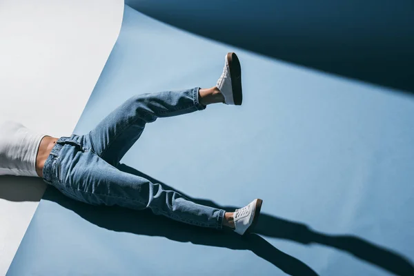 Oříznout Obrázek Stylová Holka Leží Podlaze Džínách Jednou Nohou Aktivována — Stock fotografie