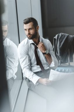 Uçuş Havaalanı lobisinde bekliyor ve uzak seyir yakışıklı genç işadamı