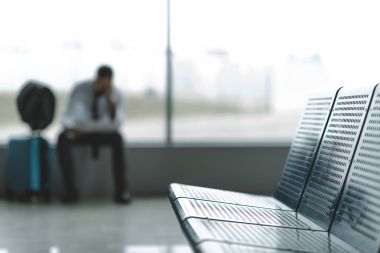 close-up shot of seats at airport lobby with buisnessman waiting for plane blurred on background clipart