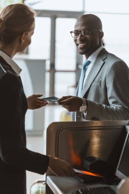 yakışıklı işadamı Havaalanı Check-Counter personel için pasaport veren gülümseyen