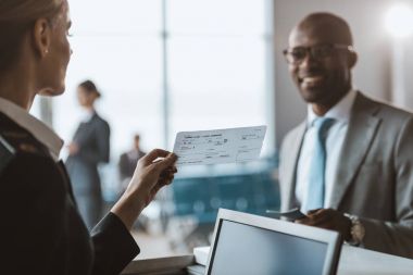 Havaalanı Check-Counter personel için pasaport veren gülümseyen Afrikalı-Amerikalı işadamı yakın çekim çekim