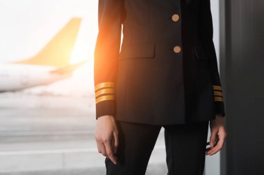 cropped shot of female pilot in professional uniform