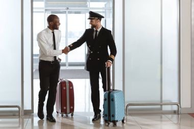 Havaalanı Kalkış alanı, genç işadamı ile mutlu yakışıklı pilot el sıkışma