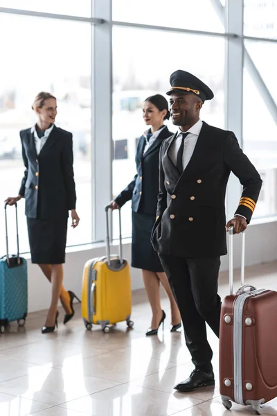 Młody Pilot Stewardessy Bagażem Chodzenie Przez Lotnisko — Zdjęcie stockowe