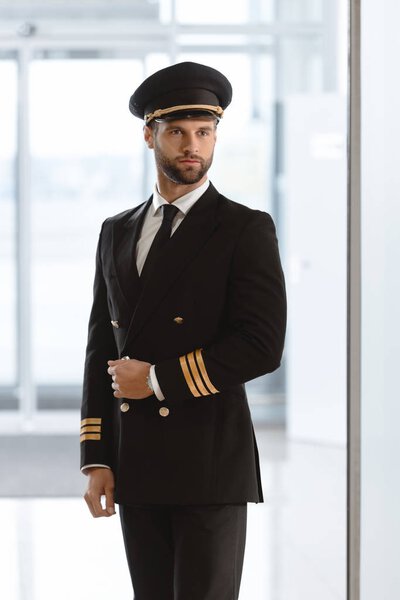 handsome young pilot in uniform at airport