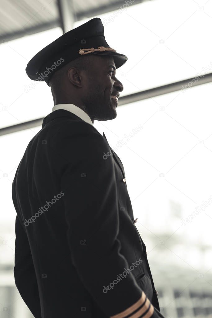 handsome young pilot looking away at airport