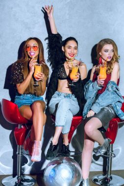 bar tabureleri oturan ve kokteyl partide içme güzel moda çok ırklı kadınlar