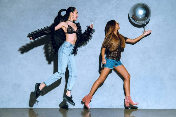 şık çok ırklı kızlar partide balon ve smartphone ile eğleniyor yan görünüm 