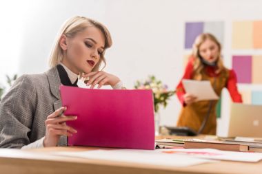 moda dergisi editörü meslektaşım meslektaşları ile modern ofis evrak işi yapıyor