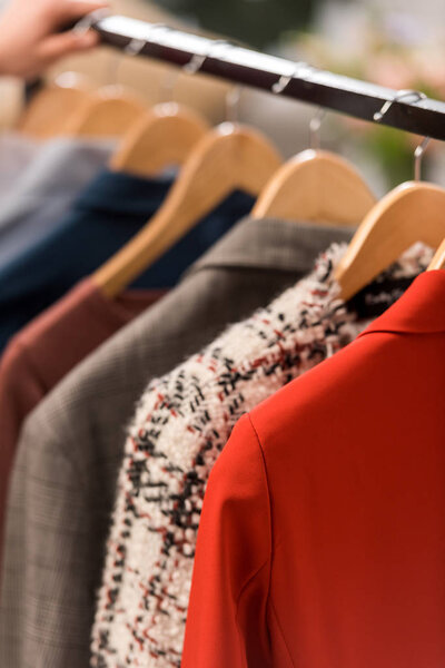 close up view of fashionable clothes on hangers 