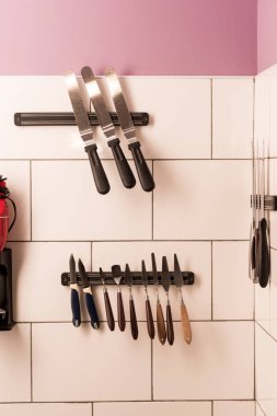 close up view of arranged kitchen and bakery supplies hanging on wall clipart