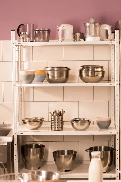 close up view of various kitchen supplies on shelves in restaurant kitchen