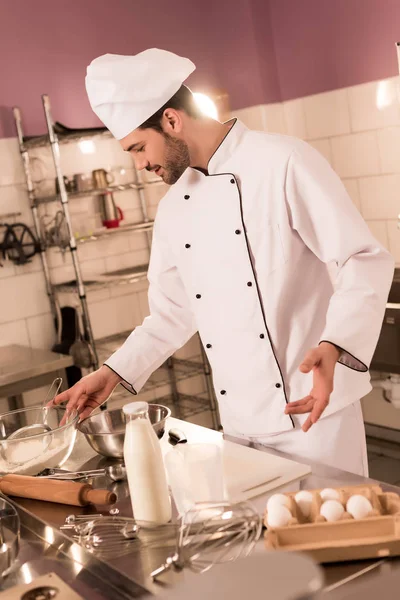 レストランの厨房で生地を作るシェフ帽子のお菓子メーカー — ストック写真