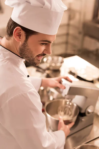 side view of confectioner cooking dessert in restaurant kitchen