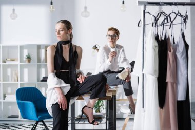 Çalışma Masası ofisinde oturup şık genç moda tasarımcıları