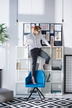 ofis sandalye üzerinde duran şık çekici moda tasarımcısı