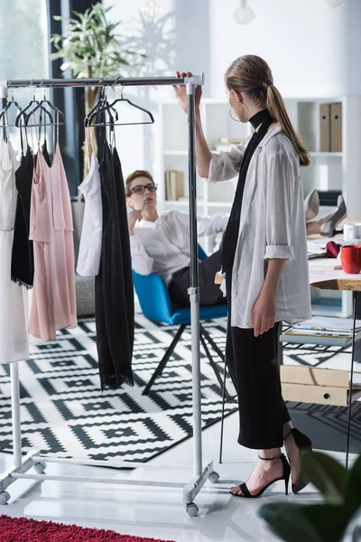 Giovani Stilisti Discutendo Nuovi Vestiti Rack — Foto Stock