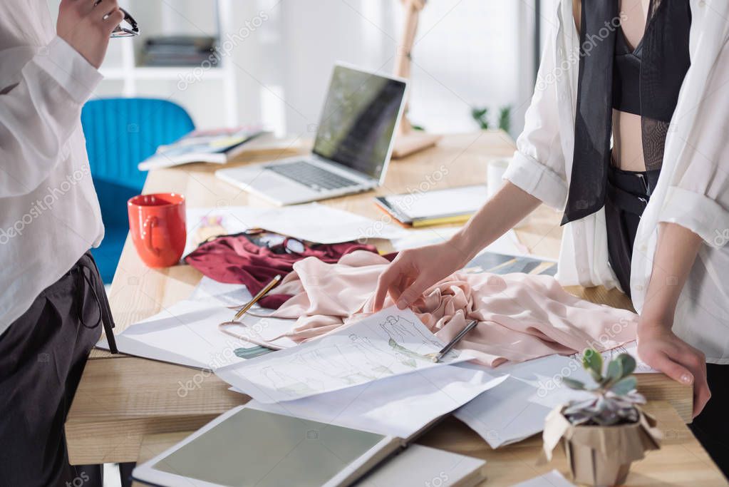 cropped shot of fashion designers working together at workplace in office