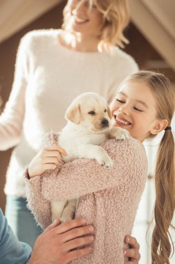 Anne ve çok güzel labrador köpek yavrusu ile oynarken mutlu küçük kızı