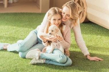 Anne ve kızı ile sevimli labrador köpek yavrusu kucaklayan