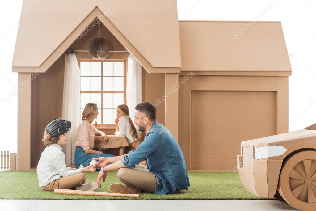 beautiful young family spending time together at cardboard house isolated on white