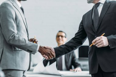 multiehtnic iş arkadaşları ofiste tokalaşırken kısmi görünümü