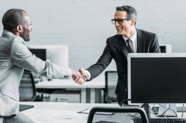 multiehtnic iş arkadaşları ofiste tokalaşırken yan görünüm