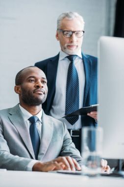 office iş yerinde bilgisayar ekranına bakarak çok ırklı iş arkadaşları