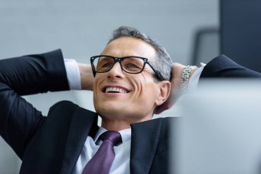 portrait of cheerful businessman in eyeglasses with hands behind head clipart