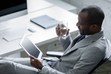 ofiste işyerinde tablet kullanma su ile Afrika kökenli Amerikalı iş adamı