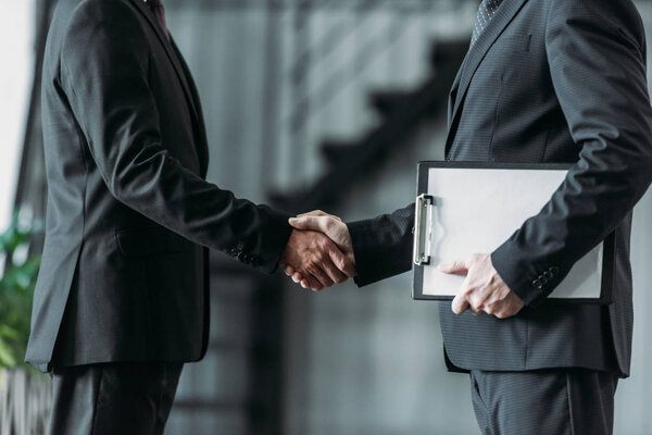 partial view of businessmen shaking hands