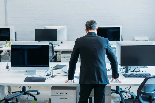 職場のオフィスで立っている実業家の背面図 — ストック写真