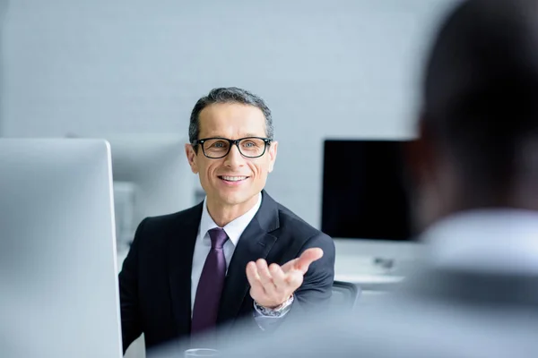 Enfoque Selectivo Sonriente Hombre Negocios Hablando Con Colega Mientras Trabaja — Foto de Stock
