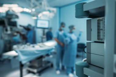 Doktor üzerinde arka plan bulanık cerrahi üniforma giymek için yardım
