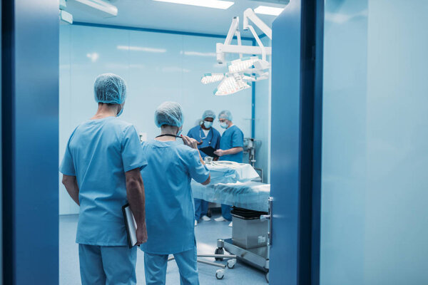 rear view of multicultural surgeons in operating room