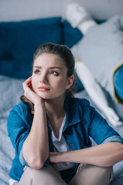 selective focus of sad woman looking away with manikin on bed, loneliness concept clipart