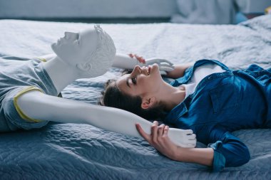 kadın ve manken yatakta, yalnızlık kavramı yatıyordu gülümseyen yan görünümü