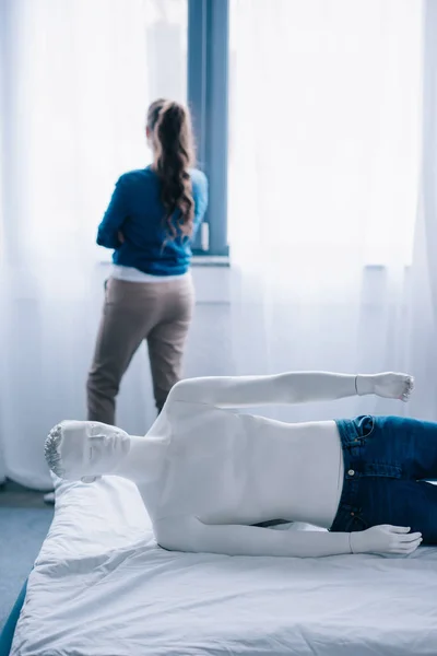 Back View Woman Standing Window Layman Doll Lying Bed Loneliness — Stock Photo, Image