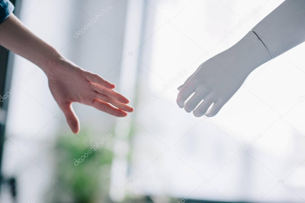 partial view of female hand and mannequins hand, loneliness concept