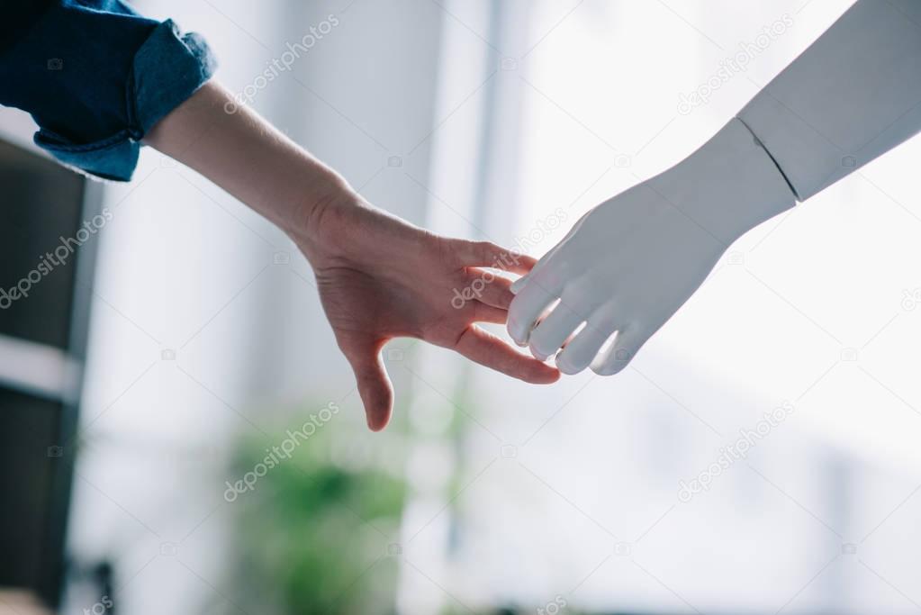cropped shot of woman and mannequin holding hands, loneliness concept
