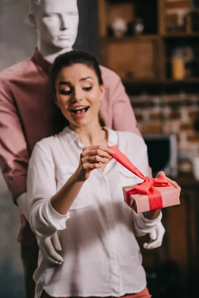 Aufgeregte Frau Öffnet Geschenk Händen Mit Manikkin Umarmt Sie Hinter — Stockfoto