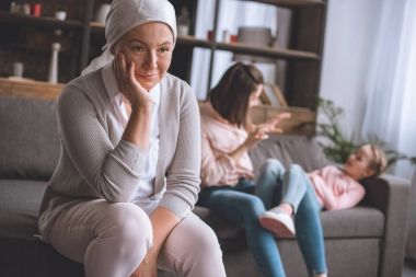 gülümseyen hasta Olgun kadın fular uzak aile üyeleri arkasında eğleniyor yaparken arıyor. 